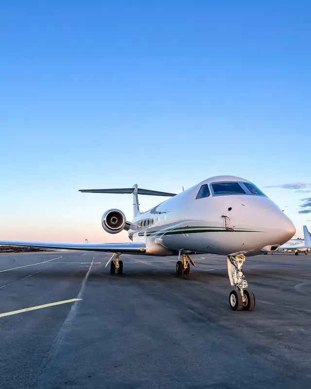 Large business jet on the ramp under a clear blue sky