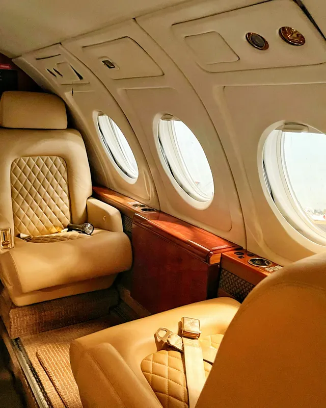 Quilted leather club seats beside the oval windows of a turboprop cabin