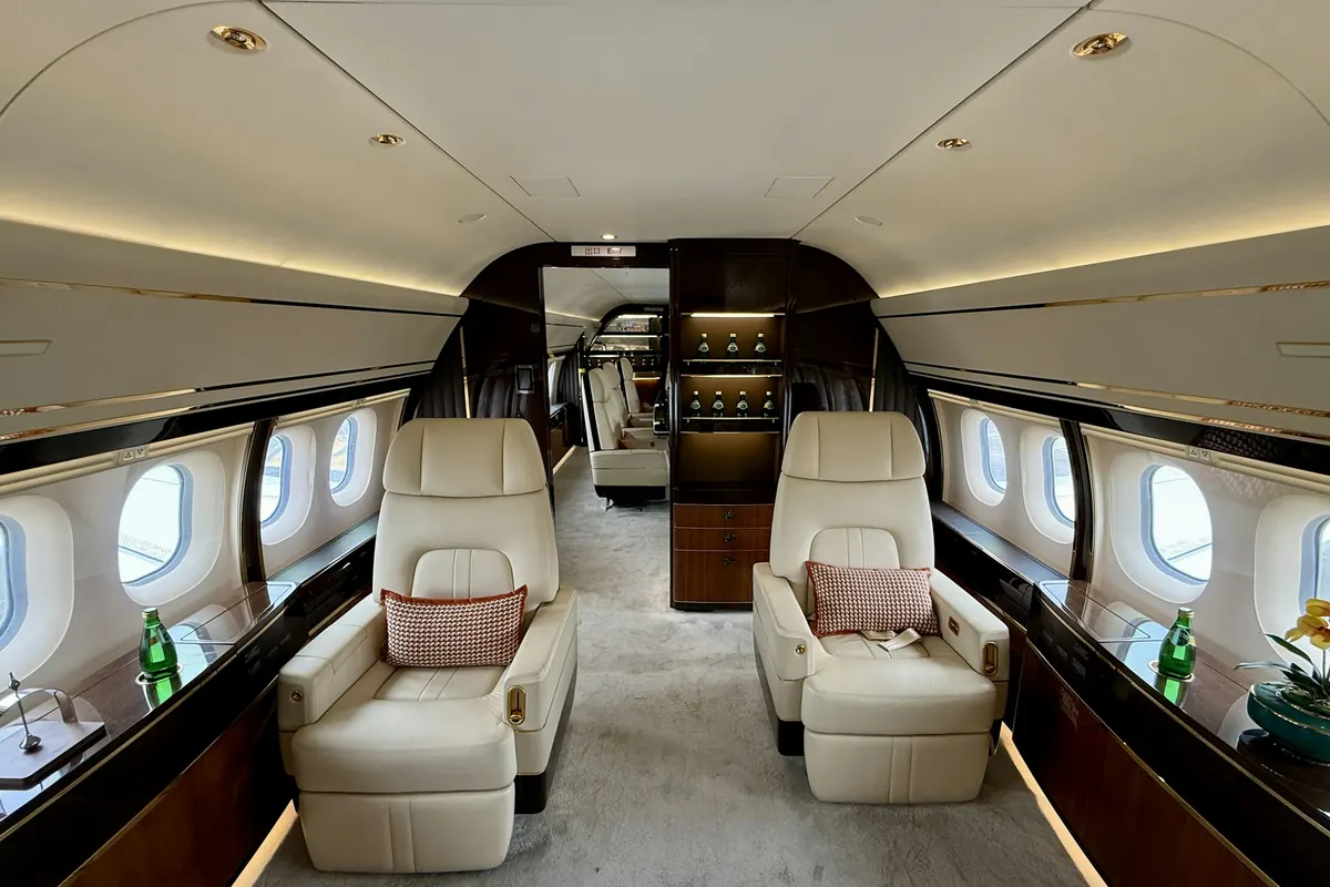 Cream leather seats facing each other in a wide private jet cabin