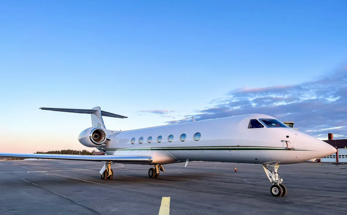 Large cabin business jet on the ramp under a clear evening sky