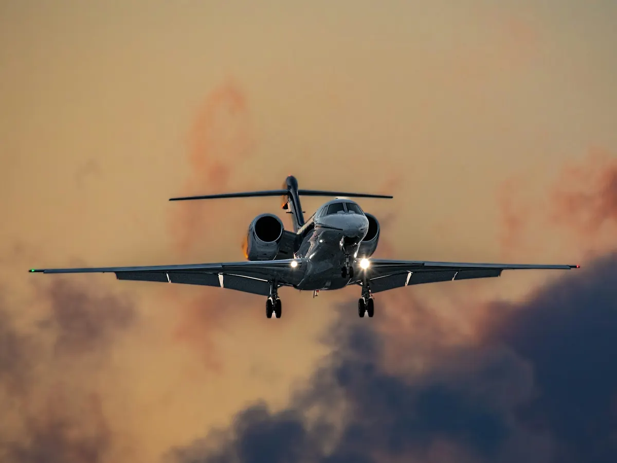 Business jet on final approach through warm, hazy cloud