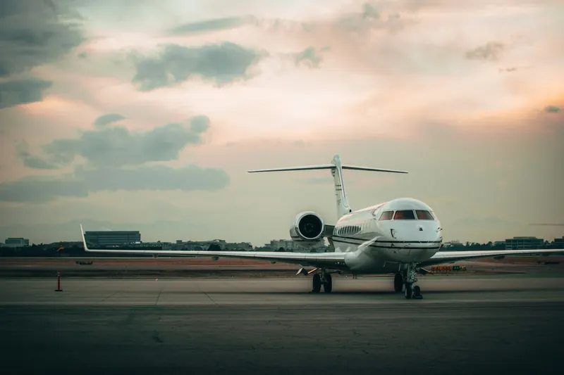 Business jet on the ramp at dusk with hills in the distance