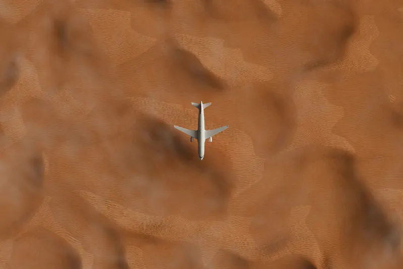 Aerial view of a jet crossing orange desert dunes